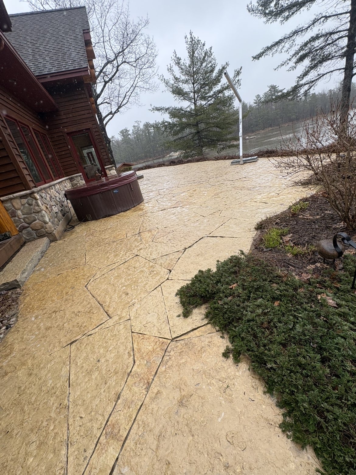 Freshly pressure-washed flagstone patio and hot tub area at a lakeside home in Sault Ste. Marie, Ontario